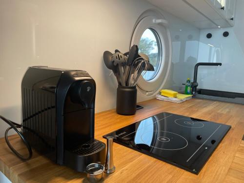 a kitchen with a microwave and a television on a counter at Modernes festliegendes Hausboot mit großzügiger Dachterrasse und Ruderboot in Röbel