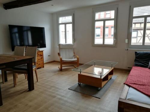 ein Wohnzimmer mit einer Couch, einem Tisch und einem Fernseher in der Unterkunft Ganzes Haus, Zentrale Lage Adenau Nürburgring in Adenau