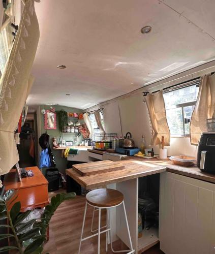 uma cozinha com um balcão e um banco num trailer em Delightful 1970's Narrowboat em Londres
