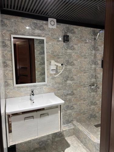 a bathroom with a sink and a mirror and a shower at Horizon Boutique in Samarkand