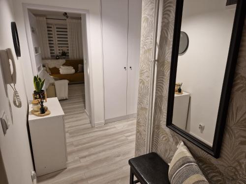 un couloir avec un miroir et un salon dans l'établissement PIK-Kwatery, à Morąg