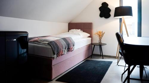 a bedroom with a bed and a table and a chair at SI-View Einzelzimmer Zimmer 9 in Siegen