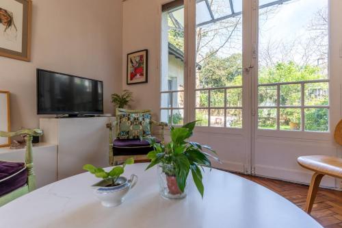 un salon avec une table et une télévision dans l'établissement Maison Marguerite - Welkeys, à Bordeaux