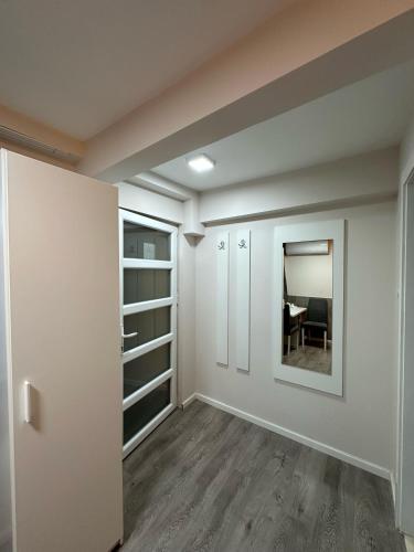 an empty room with white walls and a mirror at Vila Storia in Niš