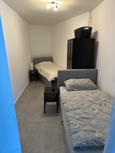 a small room with two beds and a dresser at Mani´s Feriendomizil Neuwied in Neuwied