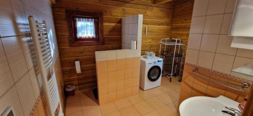 a bathroom with a toilet and a washing machine at Drevenica u Vlada in Hrabušice