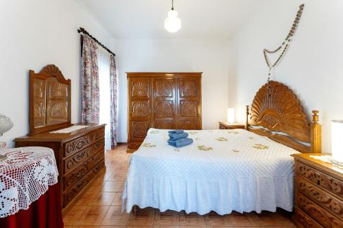 um quarto com uma cama grande e mobiliário em madeira em Alojamento Local Servinho Sebastião Maria em Sanfins do Douro