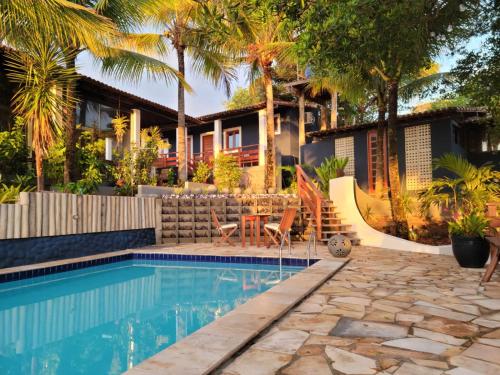 ein Haus mit einem Pool und Palmen in der Unterkunft Arandu Sagi Inn in Baía Formosa