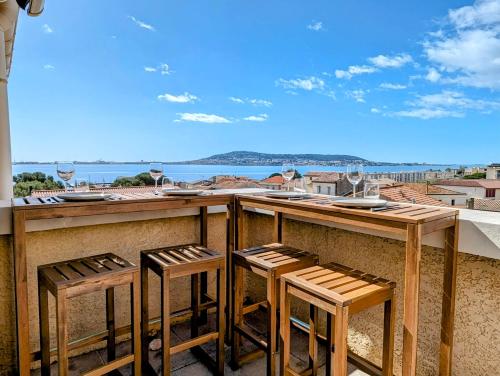 a bar with four stools and a view of the ocean at Le Belvédère - Clim Terrasse Parking privé in Balaruc-les-Bains