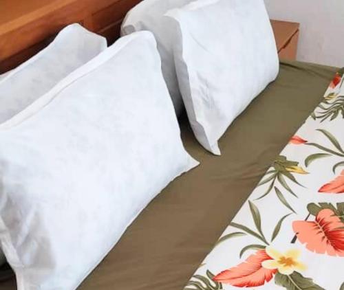 ein Bett mit zwei Kissen darüber in der Unterkunft Appartement Soleil,Batterie 4 in Libreville