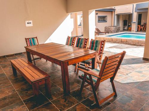 a wooden table and two chairs and a table and bench at Khutso Boutique Hotel in Hazyview