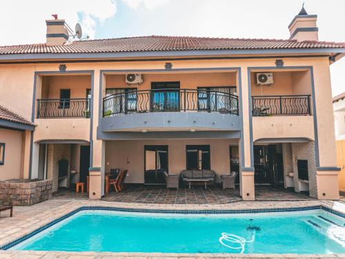 a house with a swimming pool in front of it at Khutso Boutique Hotel in Hazyview
