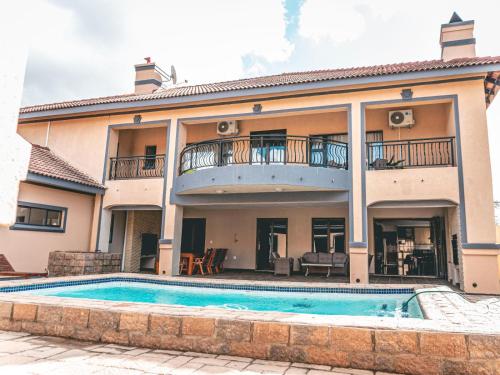 a house with a swimming pool in front of it at Khutso Boutique Hotel in Hazyview