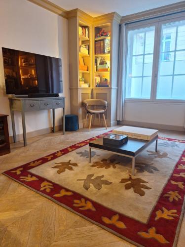 un salon avec une table basse et une télévision dans l'établissement Triplex, Parc Monceau (8eme), à Paris