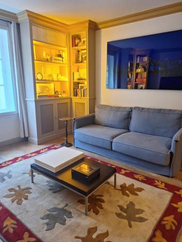 un salon avec un canapé bleu et une table basse dans l'établissement Triplex, Parc Monceau (8eme), à Paris