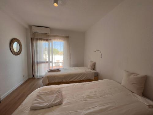 Dos camas en una habitación con ventana. en Vilamoura CasaTerra, en Quarteira