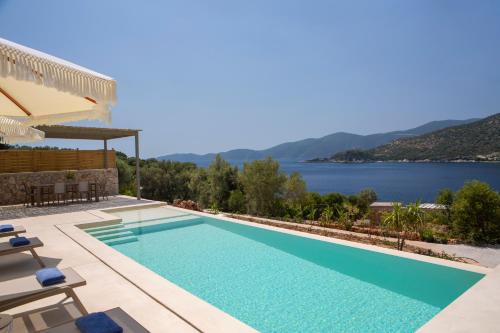een villa met een zwembad en uitzicht op het water bij Villa Armiriki-Private Sea Access in Évyiros