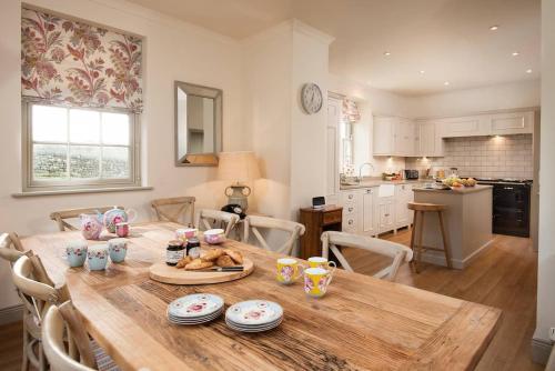 a kitchen with a wooden table and a dining room at Broadgate House & Steading in West Woodburn