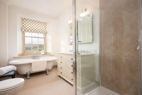 a bathroom with a shower and a sink and a toilet at Broadgate House & Steading in West Woodburn
