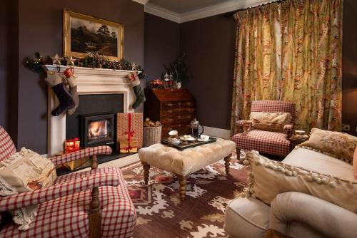 a living room with a fireplace and christmas decorations at Broadgate House & Steading in West Woodburn