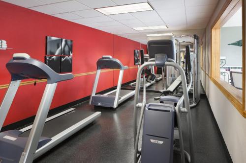 a gym with several tread machines in a red wall at Country Inn & Suites by Radisson, Columbus West, OH in Columbus