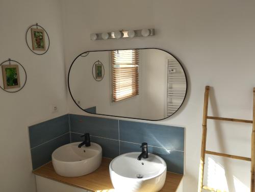 une salle de bain avec deux lavabos et un grand miroir dans l'établissement Villa Mara, à Lorgues