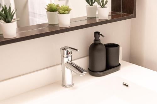 a bathroom sink with a black soap dispenser on it at DWTN Condo Near CN Tower! w/ Free Parking in Toronto