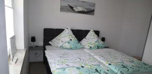 Schlafzimmer mit einem Bett mit blauer und weißer Bettwäsche und Kissen in der Unterkunft Ferienwohnung Gundermann in Quedlinburg