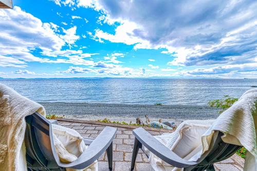 a beach with two chairs and the ocean at Half Shell, Unit 2 in Point Roberts