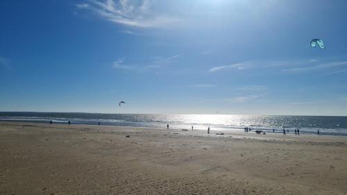 a group of people on a beach with a kite at ELLE Loc St-Brévin in Saint-Brevin-les-Pins