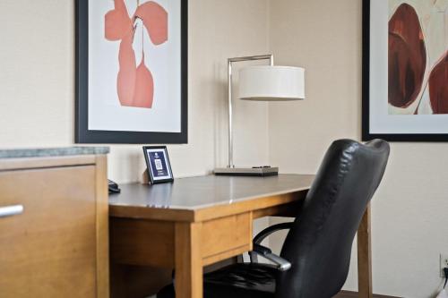 a desk with a black chair and a lamp at DoubleTree by Hilton Spokane City Center in Spokane
