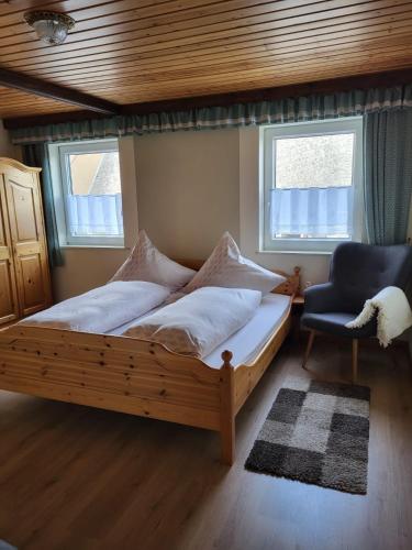 a bedroom with a wooden bed and a chair at Ferienwohnung Augustusburg in Augustusburg