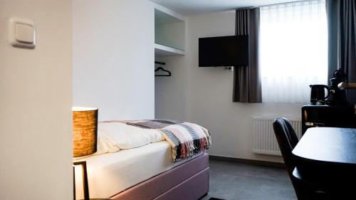 een kleine slaapkamer met een bed en een raam bij SI-View Einzelzimmer Zimmer 11 in Siegen