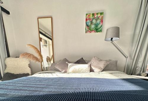 a bedroom with a bed and a mirror and a lamp at Sunny Sea View Apartment Center of Las Americas in Playa de las Americas