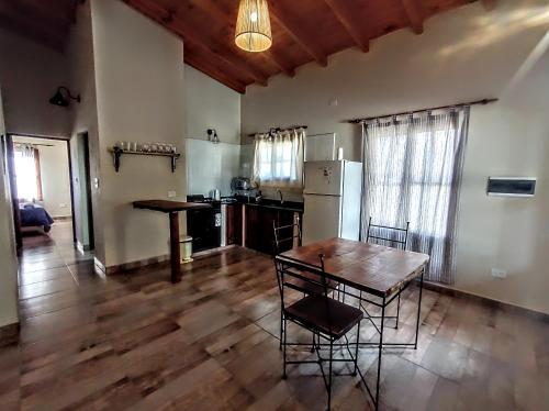 uma cozinha com mesa e cadeiras num quarto em El Aromo em Cafayate