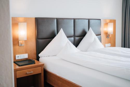 a bedroom with a large bed with a black headboard at Klostermaier Hotel & Restaurant in Icking