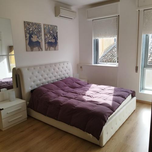 a bedroom with a large bed with purple sheets at Garibaldi Guest House in Macerata
