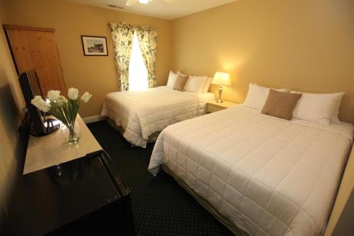 a hotel room with two beds and a vase of flowers at The Ocean Plaza Hotel in Ocean Grove
