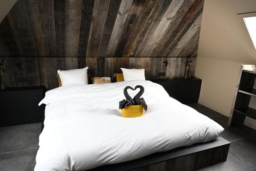 Un dormitorio con una cama con una decoración de corazón. en SUBSTANTIEL - Luxury Rooms & Wellness Suite en Brunehaut