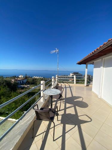 a balcony with a table and chairs and the ocean at Yard Paradise in Dhërmi
