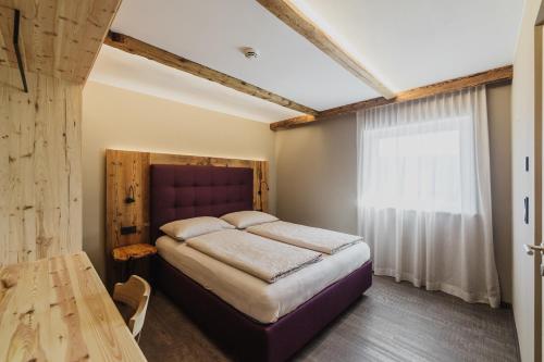 Schlafzimmer mit einem Bett, einem Tisch und einem Fenster in der Unterkunft TANOVINUM APARTMENTS Neue moderne Apartments in der Nähe von Klausen Freibad Südtirol Card inklusive in Villanders