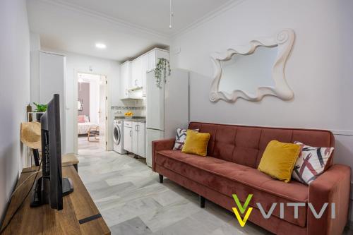 Il comprend un salon avec un canapé brun et une cuisine. dans l'établissement Vitvi Fuengirola - Chinorros Centro, à Fuengirola