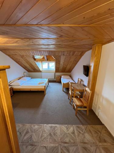 a room with two beds and a table and chairs at Privát U Mara in Poprad