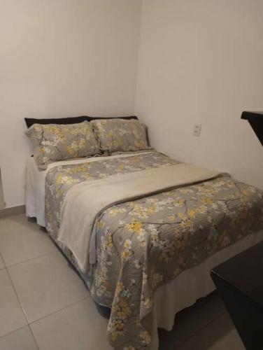 a bed with a blanket and pillows on it at casa com bela vista em Bragança Paulista in Bragança Paulista