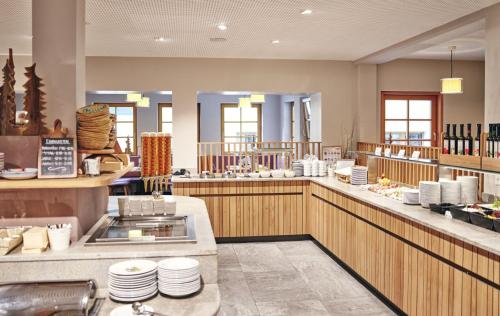a restaurant with a buffet line with white dishes at Kinderhotel Stegerhof in Donnersbachwald