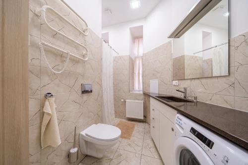 a bathroom with a toilet and a washing machine at Bright 73m2 Apartment - Blaumana Street Central in Riga