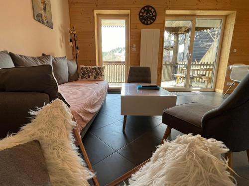 ein Wohnzimmer mit einem Sofa und einem Tisch in der Unterkunft Chalet au pied des pistes, le lioran, terrasse, 2 chambres, 4 lits in Laveissière