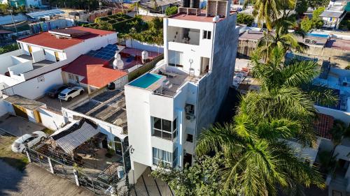 an overhead view of a white building with a palm tree at Estudio Aralias Relax & Go in Puerto Vallarta