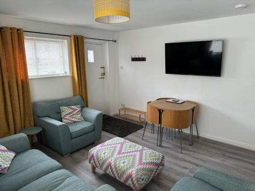 a living room with a couch and a chair and a table at The Old Coach House in Conwy