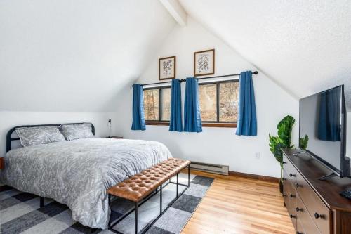 1 dormitorio con 1 cama, TV y cortinas azules en Modern Chalet Cabin w Hot Tub, Deck&Grill, & WiFi!, en Inwood
